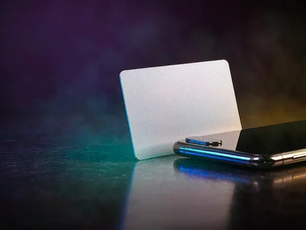 playrupees Blank card standing beside a smartphone